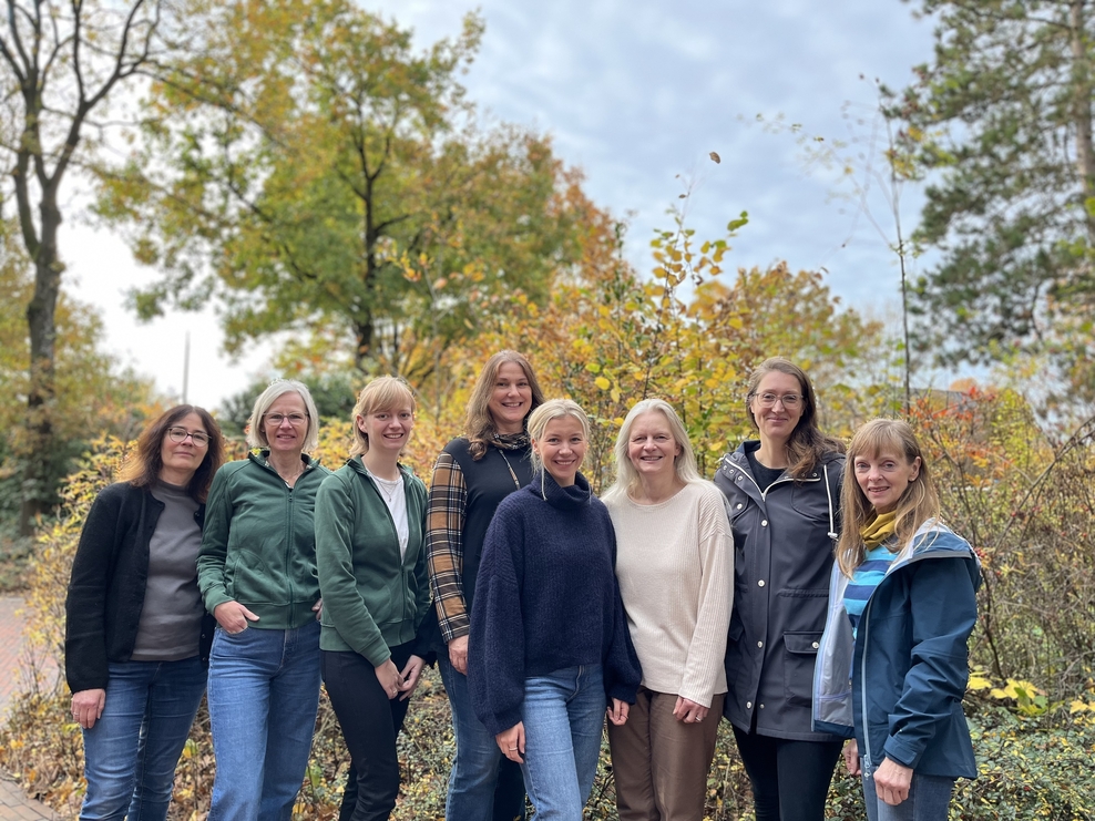 Gruppenbild mit acht Frauen vor einem herbstlichen Beet