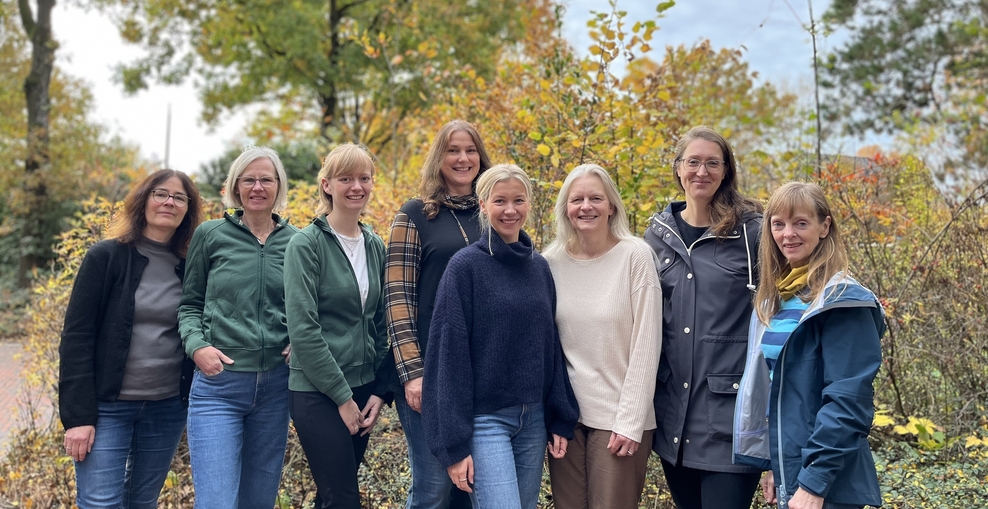 Gruppenbild mit acht Frauen vor einem herbstlichen Beet