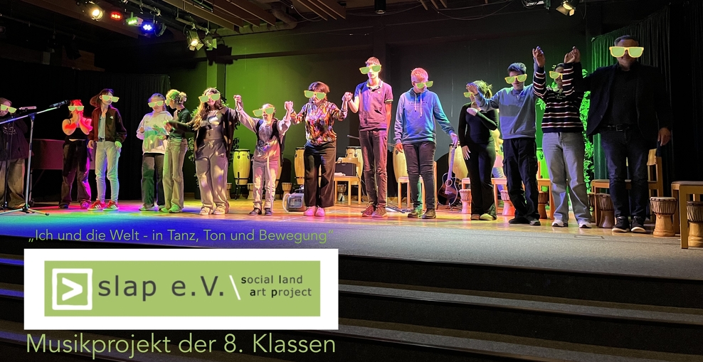 Foto von Kindern einer 8. Klasse auf der Bühne nach der Aufführung eines Musikprojektes